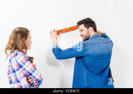 Vista posteriore del fidanzato la misurazione della planarità della parete Foto Stock