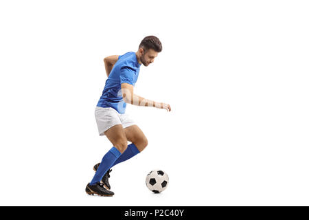 Lunghezza piena ripresa di profilo di un giocatore di calcio dribbling isolati su sfondo bianco Foto Stock