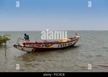 Cacheu, Repubblica di Guinea Bissau - Febbraio 1, 2018: pescatore preparando la sua canoa nel porto della città di Cacheu in Guinea Bissau. Foto Stock