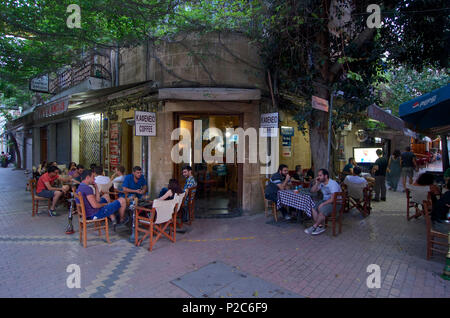 La gente seduta ai tavoli in un caffè in una strada Lefkosia, Nicosia, Cipro Foto Stock