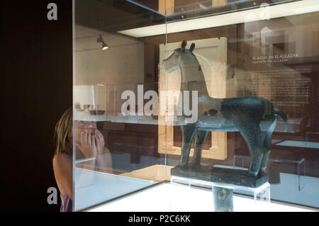 Ragazza stupito da una scultura in bronzo di un cavallo nel centro visitatori presso Medina Azahara, Cordoba, Andalusia, Spagna Foto Stock