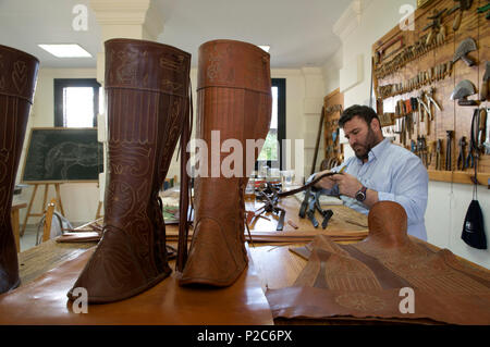 Calzolaio lavora nel Real Escuela de Caballo, Scuola Reale Andalusa di Arte Equestre, Jerez de la Frontera, Andalusia, Sp Foto Stock
