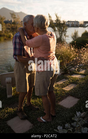 Coppia senior che abbraccia ogni altra vicino riverside Foto Stock