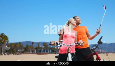 Giovane con la bicicletta e lo smartphone selfie stick Foto Stock