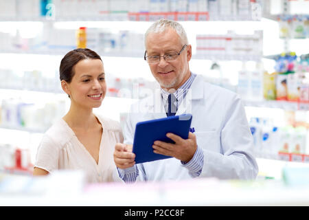 Il farmacista e il cliente con i tablet pc in farmacia Foto Stock