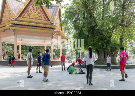 Gruppo del popolo cambogiano giocando volano Kick gioco (chiamato anche isc o Sey) in un parco di Phnom Pehn, Cambogia, Asia Foto Stock