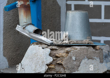 Una benna e un serbatoio di accumulo dell'acqua. Serva bene. Foto Stock