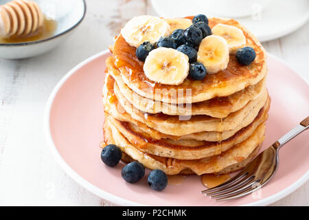Pila di Pancake fatti in casa con more e banana sulla piastra di rosa Foto Stock