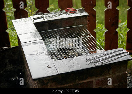 La pioggia caduta sul barbecue di mattoni nel regno unito su una tipica pioggia britannica giorno di estate Foto Stock