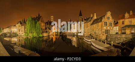 Panoramica e notturna vista iconico di storici edifici medievali lungo un canale dal Rozenhoedkaai a Bruges, Belgio. Edifici, alberi e barche Foto Stock