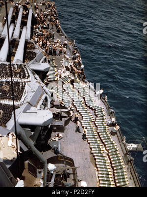 . 14 pollici (35,6 cm) proiettili sul ponte dell'U.S. Navy Corazzata USS Nuovo Messico (BB-40), mentre la corazzata fu il rifornimento la sua fornitura di munizioni prima dell'invasione di Guam, luglio 1944. La fotografia guarda avanti sul lato di dritta con tripla 14'/50 torrette mitragliatrici a sinistra. Nota reti floater stivato in cima le torrette. Luglio 1944. USN 1 14in gusci sul ponte della USS New Mexico (BB-40) nel 1944 Foto Stock