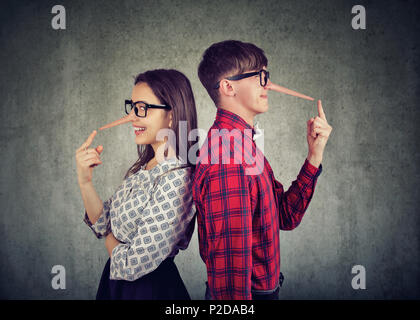 Coppia giovane di imbroglioni, satnding back to back due bugiardi Foto Stock