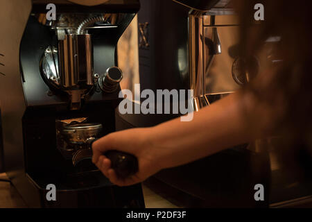 Cameriera holding portafilter riempito di caffè macinato Foto Stock