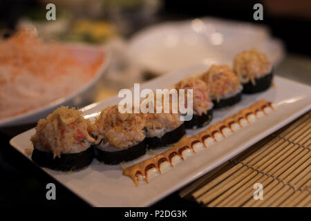 Sushi servita in una piastra con salsa di guarnito Foto Stock