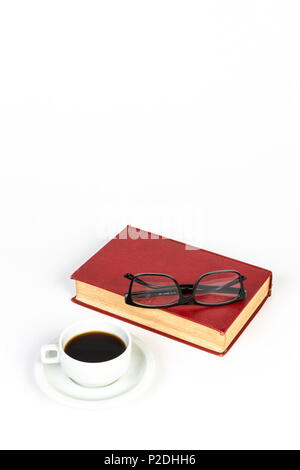 Un rosso libro vintage, una tazza di caffè e occhiali neri su sfondo bianco. Foto Stock