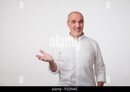 Che cosa si intende per concetto. Perplesso uomo maturo in maglia bianca Foto Stock