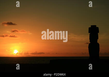 Splendida vista il sole tramontare sull'Oceano Pacifico con il moai la silhouette a Ahu Tahai, Isola di Pasqua, Cile Foto Stock