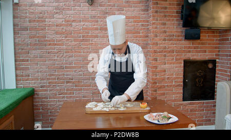 Passo dopo passo il procedimento di preparazione di gnocchi, ravioli o pelmeni con ripieno a base di pesce Foto Stock