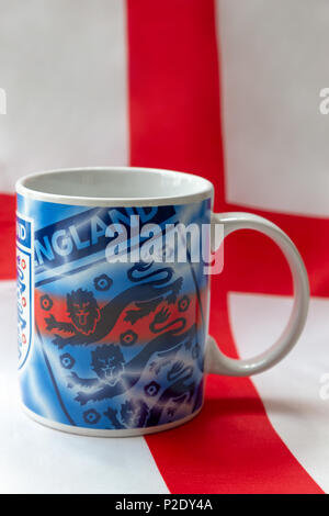 14 Giugno 2018 - Bere mug recanti i tre leoni badge seduto su una bandiera inglese prima del 2018 FIFA World Cup International Football Tournamen Foto Stock