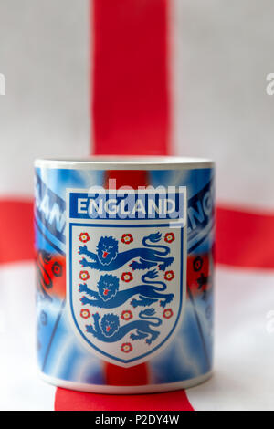 14 Giugno 2018 - Bere mug recanti i tre leoni badge seduto su una bandiera inglese prima del 2018 FIFA World Cup International Football Tournamen Foto Stock