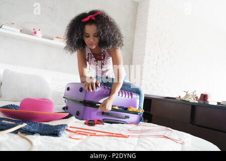 African American Girl preparare i bagagli per le vacanze e viaggi Foto Stock