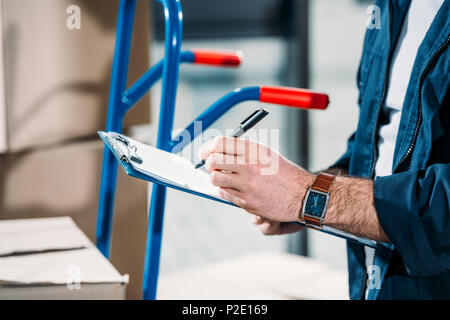 Vista ravvicinata della consegna uomo riempimento dichiarazione di carico Foto Stock