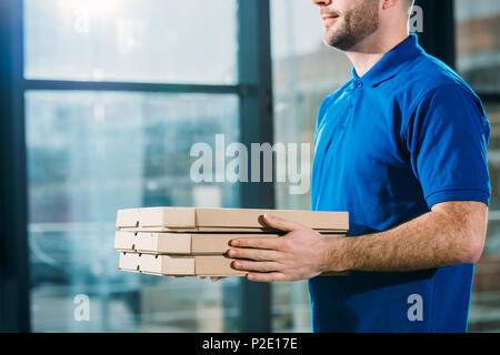 Vista ravvicinata di delivery guy holding pizze in scatole Foto Stock