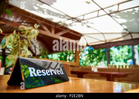 Una compressa di nero è riservato su una tavola di legno in una caffetteria estiva. Foto Stock