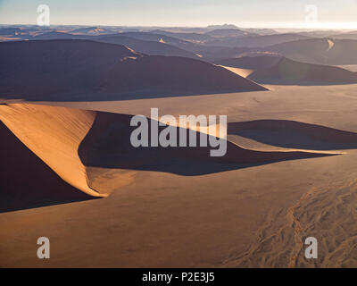 Dune rosse che salgono dal pavimento del deserto Foto Stock