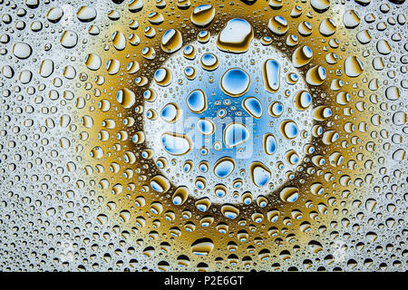 In prossimità di una di gocce di acqua su un blu e marrone a gradiente dello sfondo, coperto con gocce di acqua : la condensazione. Foto Stock