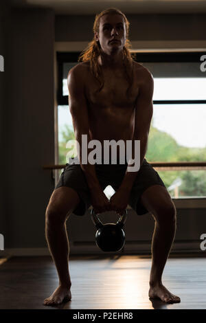 L'uomo esercita con kettlebell Foto Stock