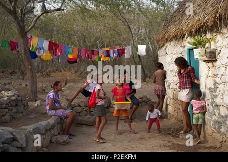 Capo Verde, Santo Antao, Ribeira das Patas, gruppo di bambini dietro una tradizionale casa in pietra e tetto di paglia Foto Stock