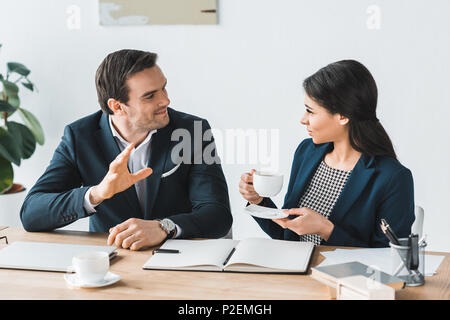 Imprenditore e imprenditrice avente una discussione circa il progetto in un ufficio moderno Foto Stock