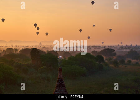 Palloni aerostatici che fluttuano sopra le antiche pianure del tempio di Bagan all'alba nebbiosa, Myanmar Foto Stock