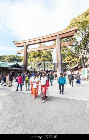Due giovani donne giapponesi sulla venuta di età la giornata davanti a Torii di legno del tempio di Meiji, Shibuya, Tokyo, Giappone Foto Stock