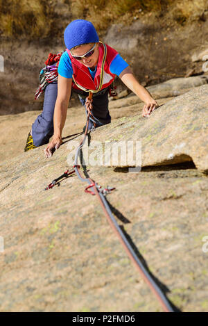 Donna arrampicata su granito rosso rock, il Mottarone, Piemonte, Italia Foto Stock