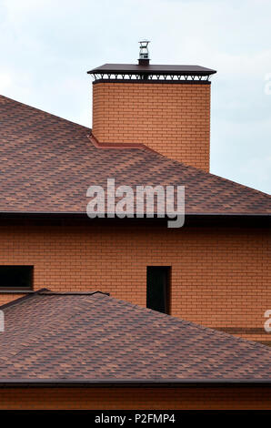 La casa è dotata di alta qualità di coperture di herpes zoster (bitume piastrelle). Un buon esempio di perfetta copertura. Il tetto è protetta in modo affidabile dall annuncio Foto Stock