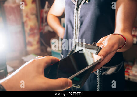 Momento del pagamento per l'acquisto di uno smartphone attraverso un terminale senza fili Foto Stock