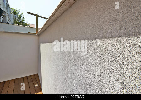 Rinnovato white ciment parete e nuovo pavimento in legno in cortile Foto Stock