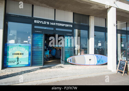 Lyme Regis, barca per sport acquatici, negozio di vela, lezioni, ingresso anteriore, vendita di abiti a porte aperte, cartelli per visite, esterno, montante in vetro Foto Stock