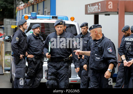 15 giugno 2018, Germania, Colonia: poliziotti in piedi davanti al complesso residenziale Osloerstr. 3 in Cologne-Chorweiler. La polizia sta cercando il venerdì mattina attraverso diversi svuotato appartamenti dell'edificio dopo altamente velenoso il ricin è stato trovato lì. Foto: Oliver Berg/dpa Foto Stock