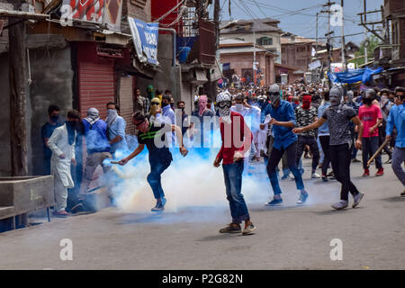 Un manifestante Kashmir getta indietro un esploso di una lacerazione barattolo di fumo verso le forze di governo durante gli scontri con forze di sicurezza indiane durante una manifestazione di protesta a Srinagar, Kashmir indiano il Venerdì . Le forze governative hanno utilizzato gas lacrimogeni e agglomerati in forma di pellets il Kashmiris manifestanti che si sono riuniti dopo lo scorso venerdì pomeriggio preghiere , i manifestanti hanno protestato contro la regola di indiana nella regione contesa. Foto Stock