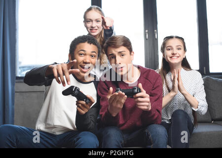 Felice adolescenti multiculturale per giocare con i videogiochi con joystick a casa, gli adolescenti divertendosi concept Foto Stock