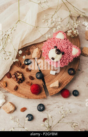 Vista dall'alto di deliziosi muffin in forma di orso con i frutti di bosco sulla tavola di legno Foto Stock