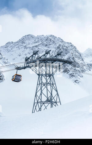 Gondola della funivia al ghiacciaio dello Stubai ski resort con montagne innevate come sfondo, Neustift im Stubaital, Alpi austriache, Tirolo, Austria Foto Stock