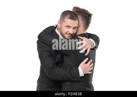 Coppia omosessuale di stallieri nelle tute abbracciando isolato su bianco Foto Stock