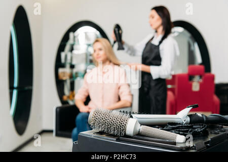 Parrucchiere di asciugatura dei capelli del cliente rotonde con spazzola per capelli in primo piano Foto Stock