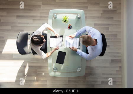 Vista in elevazione di due imprenditori azienda riprendere sulla scrivania in ufficio Foto Stock