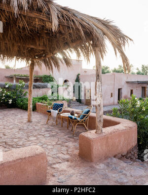 Una coppia di sedie di rattan sulla terrazza giardino con muri di terra, erbe e marocchine piante selvatiche. Garden design di Arnaud Casaus Foto Stock