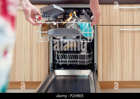 Immagine della mano della ragazza aprendo la lavastoviglie con i piatti sporchi Foto Stock